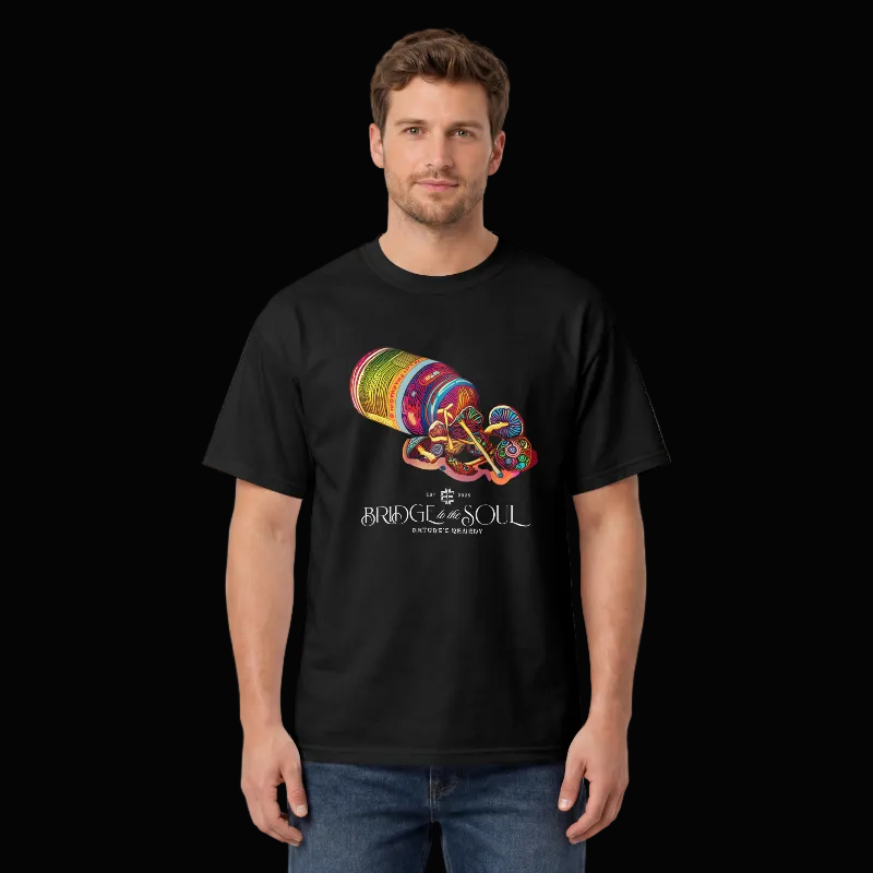 A man wearing a black short-sleeve t-shirt with a colorful graphic of a mushrooms spilling out of a pill vial and the text 'BRIDGE TO THE SOUL-NATURES REMEDY' on the front, set against a black background