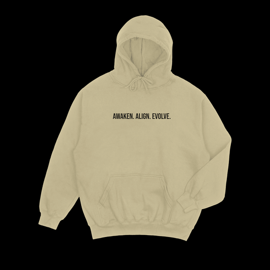 Sand hoodie with black puff text 'AWAKEN. ALIGN. EVOLVE.' on a black background